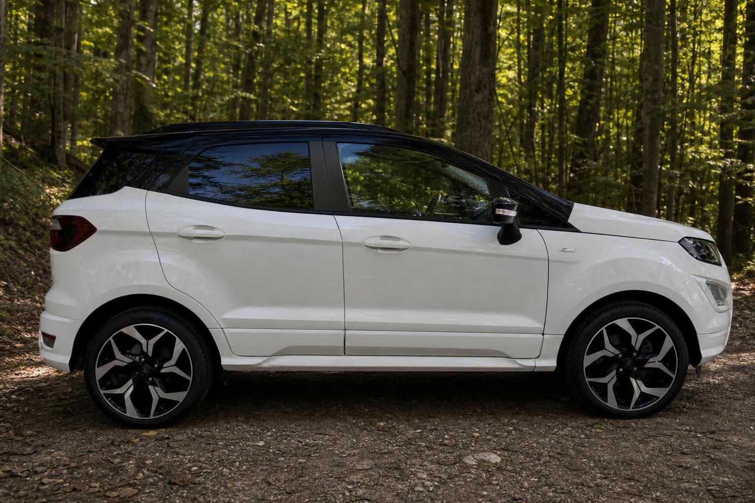 Weißer Ford EcoSport SUV Seitenansicht mit schwarzem Dach und Sportfelgen im Wald