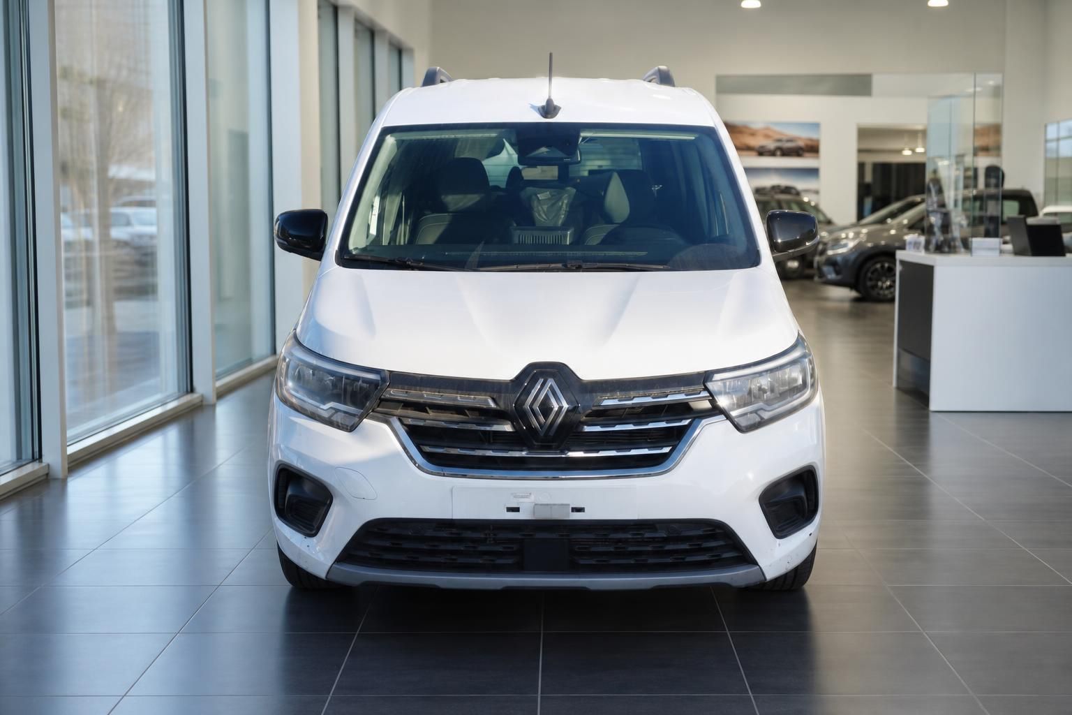 Weißer Renault Van in modernem Autohaus-Showroom - Frontansicht mit Renault-Logo