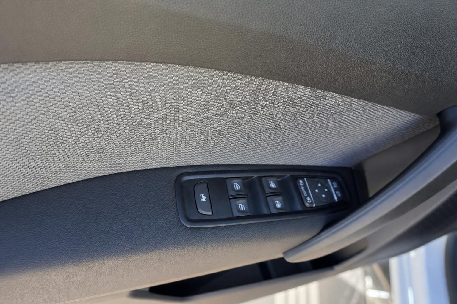 Fahrzeugtür Innenbereich mit Fensterheber-Bedienfeld und Stoffverkleidung