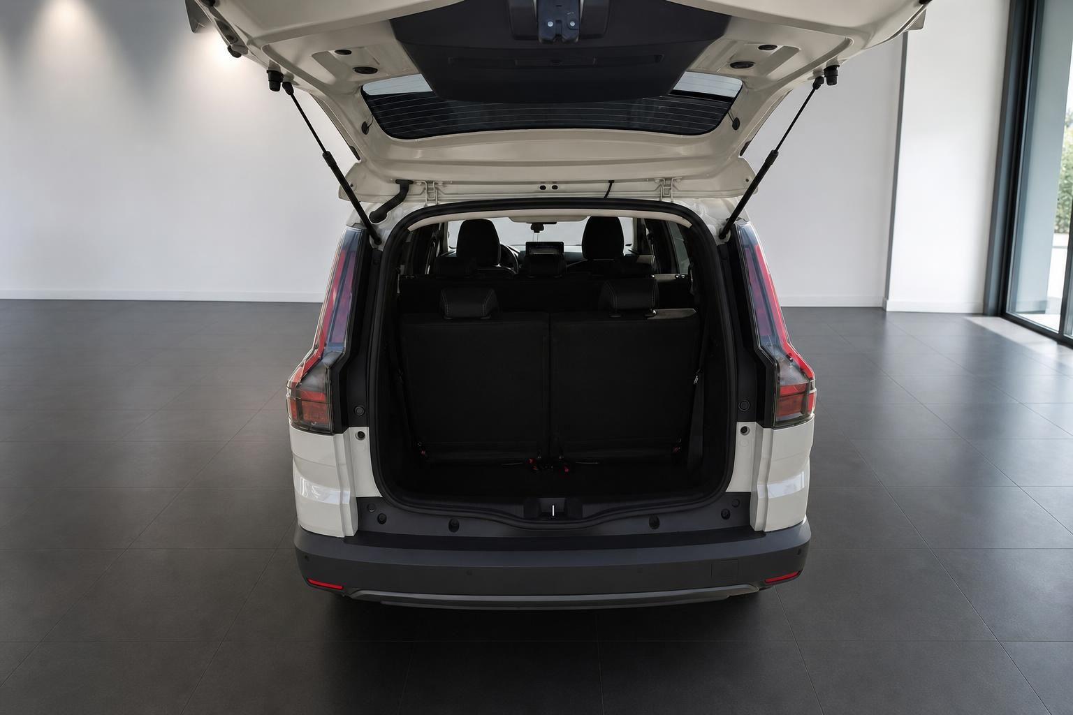 Weißer SUV mit geöffneter Heckklappe und Blick in den großzügigen Kofferraum im Autohaus