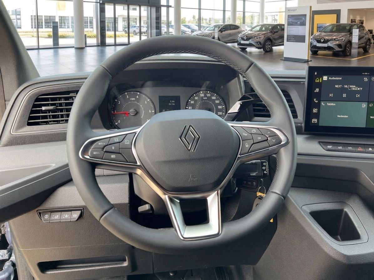 Detailaufnahme Lenkrad und Cockpit mit Renault-Logo und Bordcomputer im Fahrzeuginnenraum