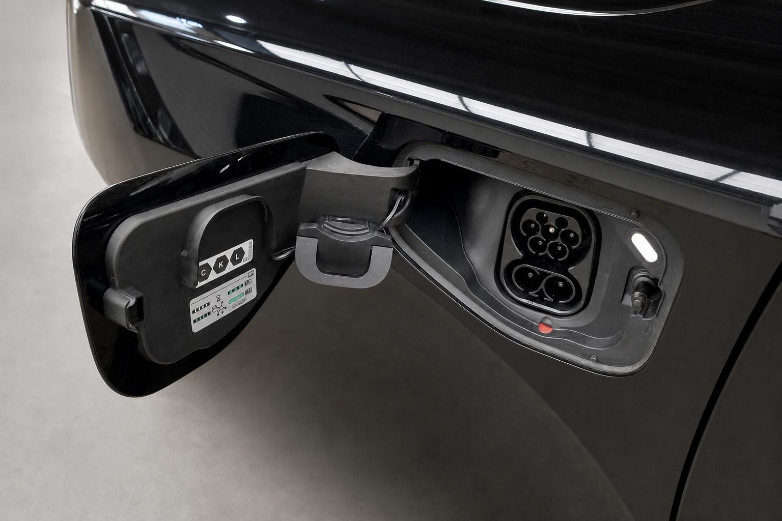 Ladeanschluss für Elektrofahrzeug an schwarzer Karosserie