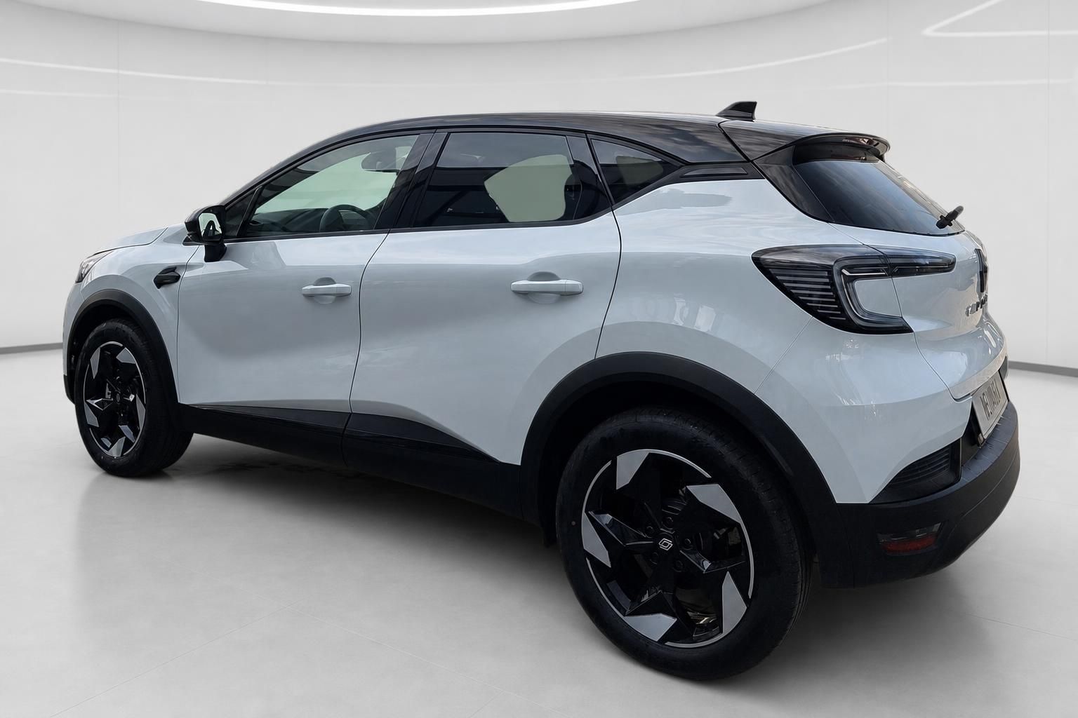 Renault Captur weiss Heckansicht schraeg im modernen Showroom