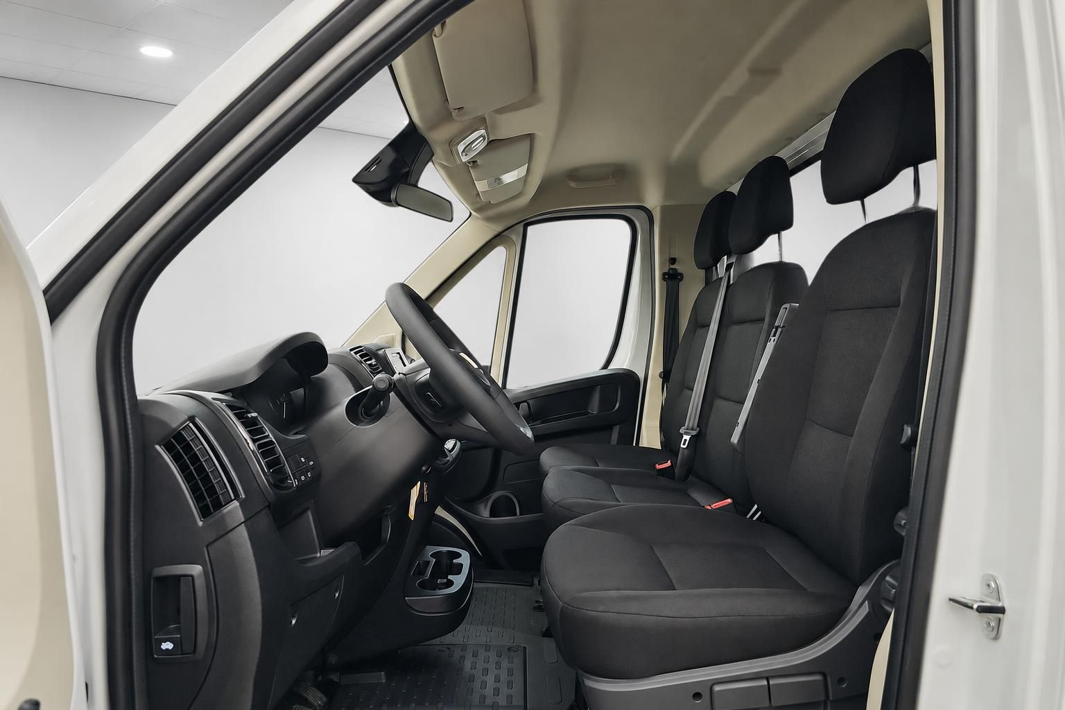 Innenraum Fiat Ducato mit schwarzen Stoffsitzen und Sicherheitsgurten