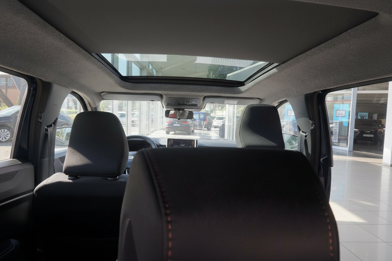 Fahrzeuginnenraum mit Panoramadach, schwarze Stoffsitze mit roten Ziernähten, Blick vom Rücksitz