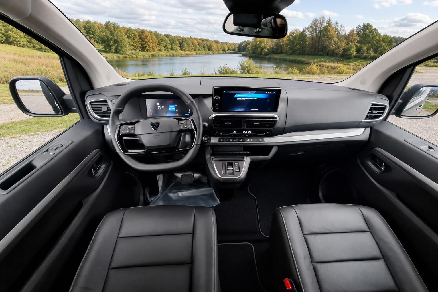 Modernes Fahrzeug Cockpit mit digitalen Anzeigen und Touchscreen vor Naturlandschaft