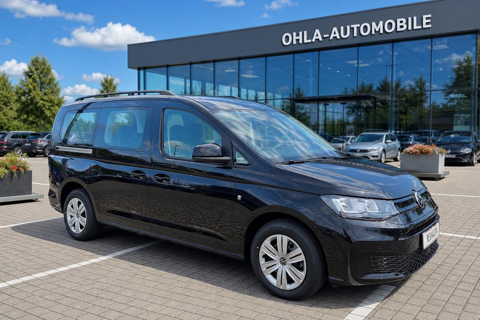 VW Caddy schwarz Dreiviertelansicht vorne vor Autohausgebaeude