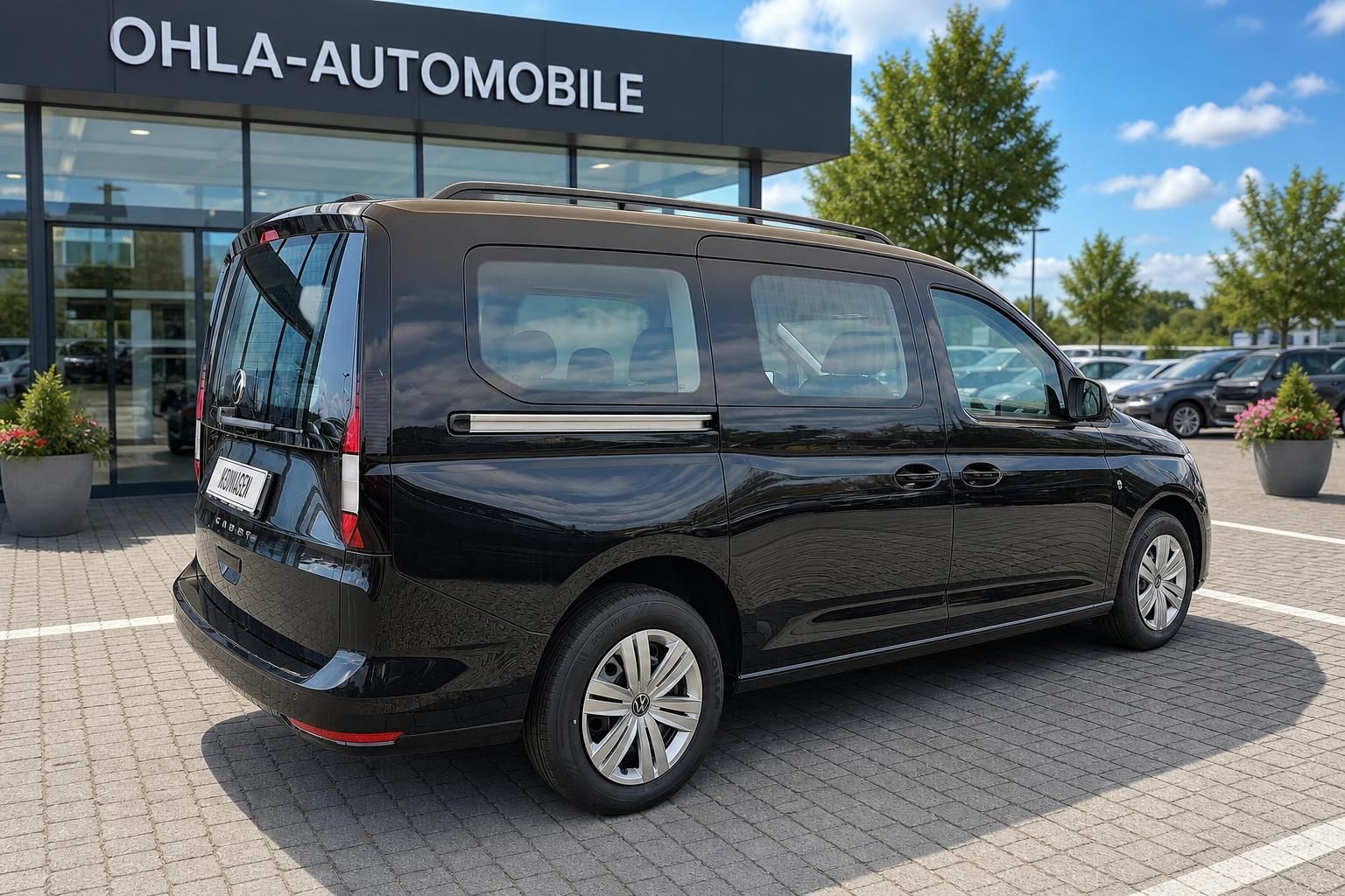 VW Caddy schwarz Heck-Seitenansicht vor dem Autohaus