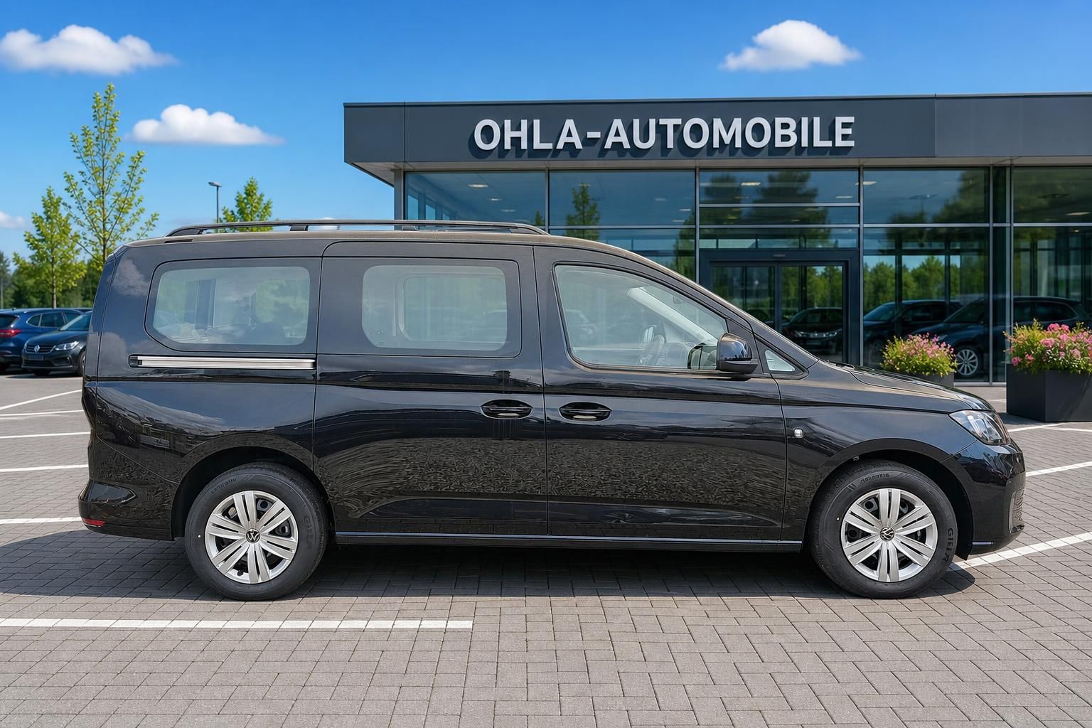 VW Caddy schwarz Seitenansicht bei Ohla-Automobile geparkt