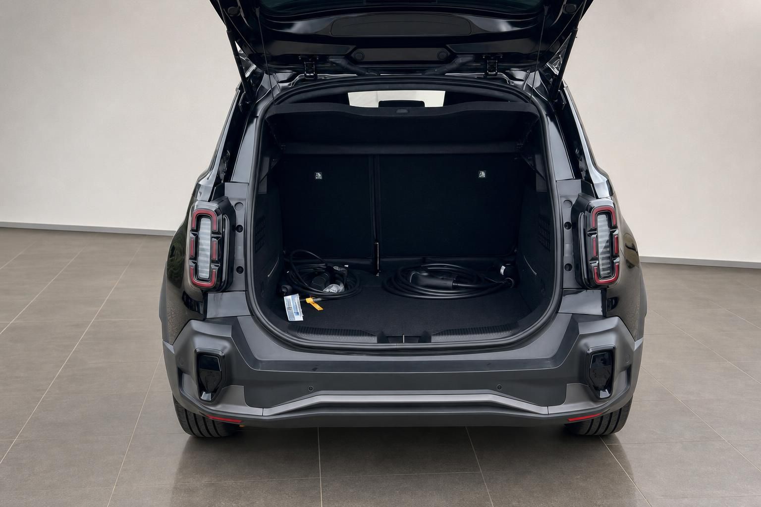 Kofferraum eines schwarzen SUV mit Ladekabeln von hinten