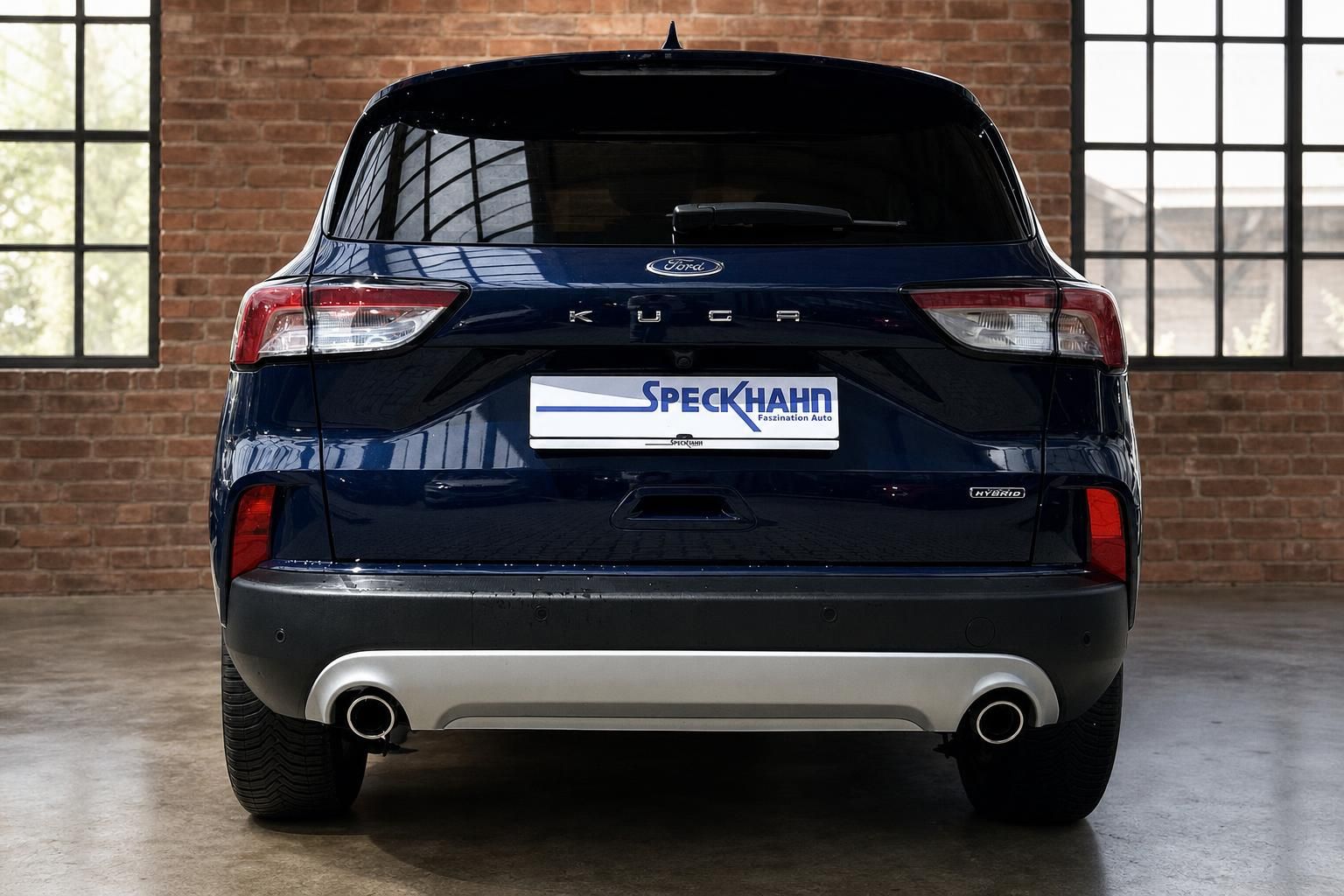 Ford Kuga Hybrid blau, direkte Heckansicht mit Kennzeichenhalter Speckhahn