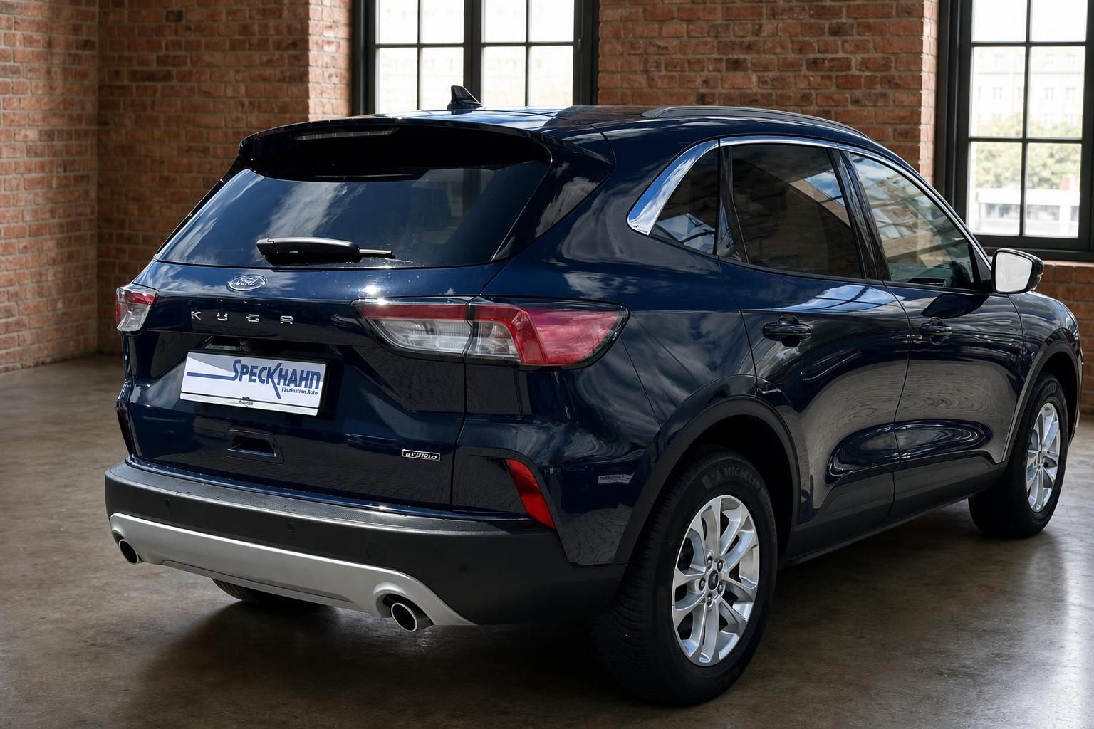 Ford Kuga dunkelblau, Heckansicht seitlich mit Hybrid-Schriftzug