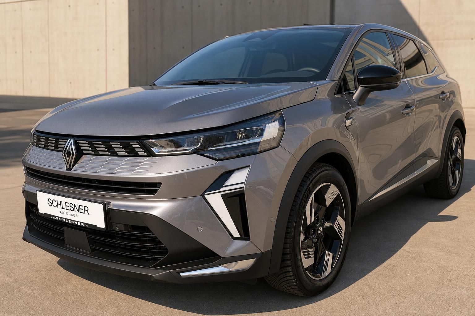 Renault SUV Grau schraeg von vorne vor Betonwand fotografiert