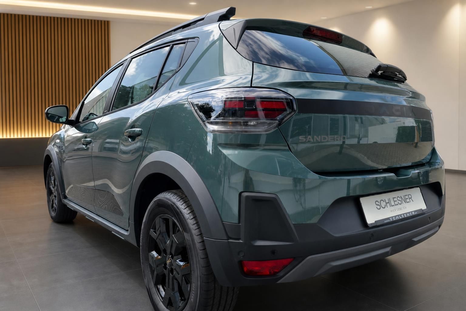 Dacia Sandero Stepway grün, Heckansicht seitlich im Showroom