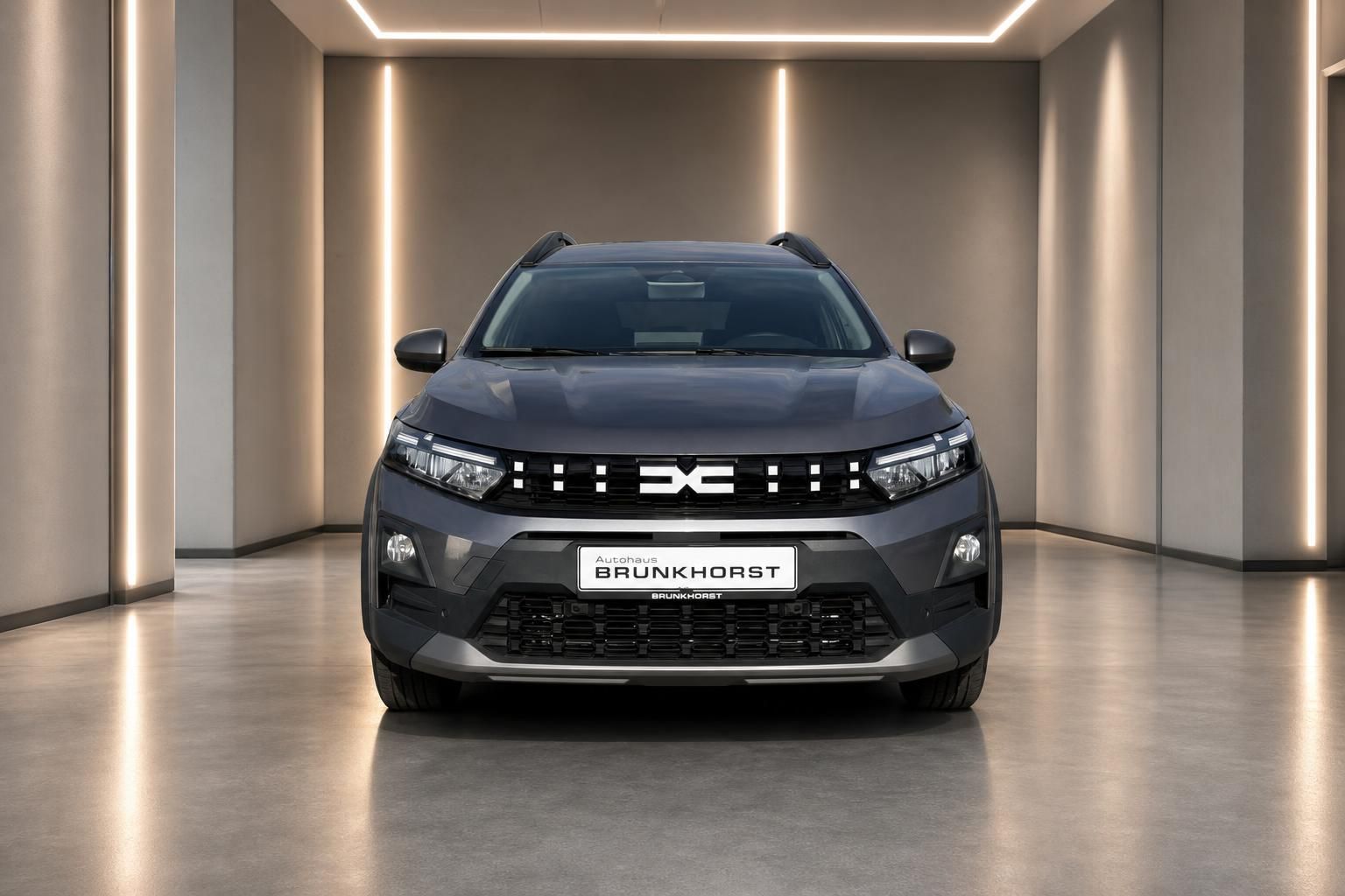 Dacia SUV grau metallic Frontansicht mit LED-Scheinwerfern und markanter Kühlergrill im stilvollen Showroom