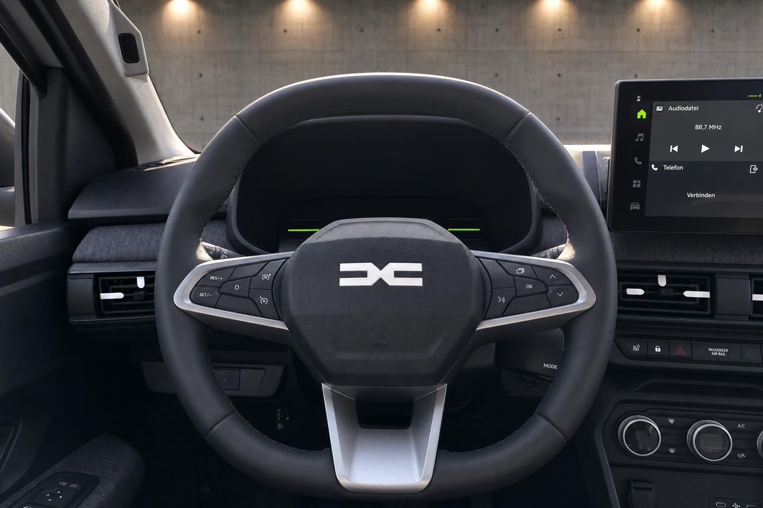 Dacia Cockpit mit multifunktionalem Lenkrad, digitalem Display und Touchscreen-Infotainment in dunklem Design