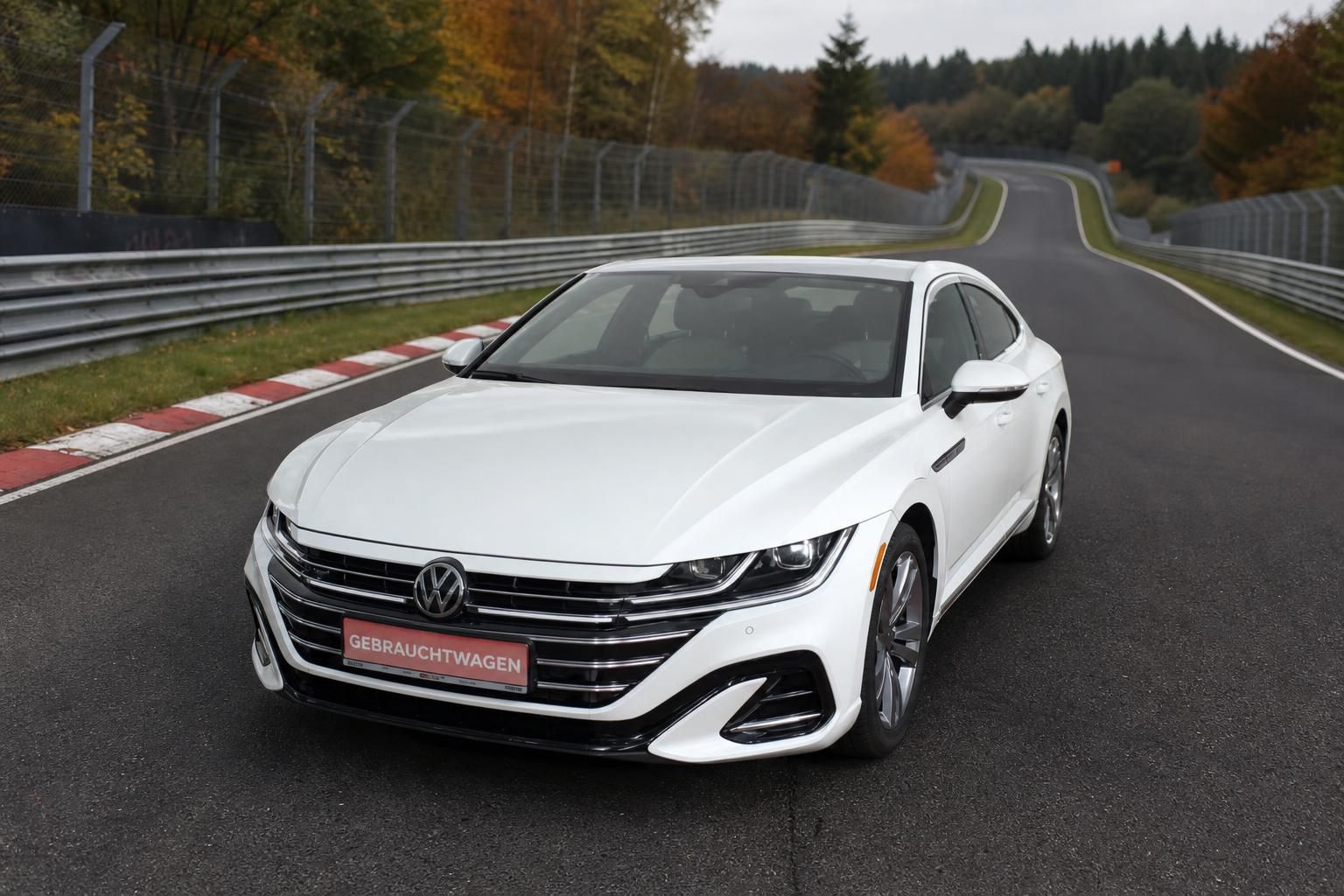 VW Arteon Gebrauchtwagen weiß Frontansicht auf Rennstrecke im Herbst