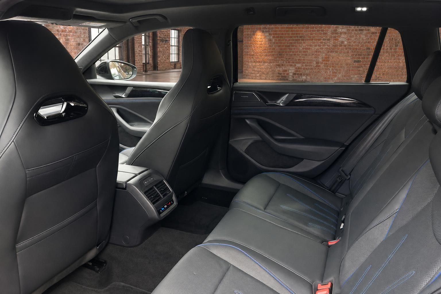 VW Rücksitzbank mit schwarzem Lederinterieur und blauen Ziernähten
