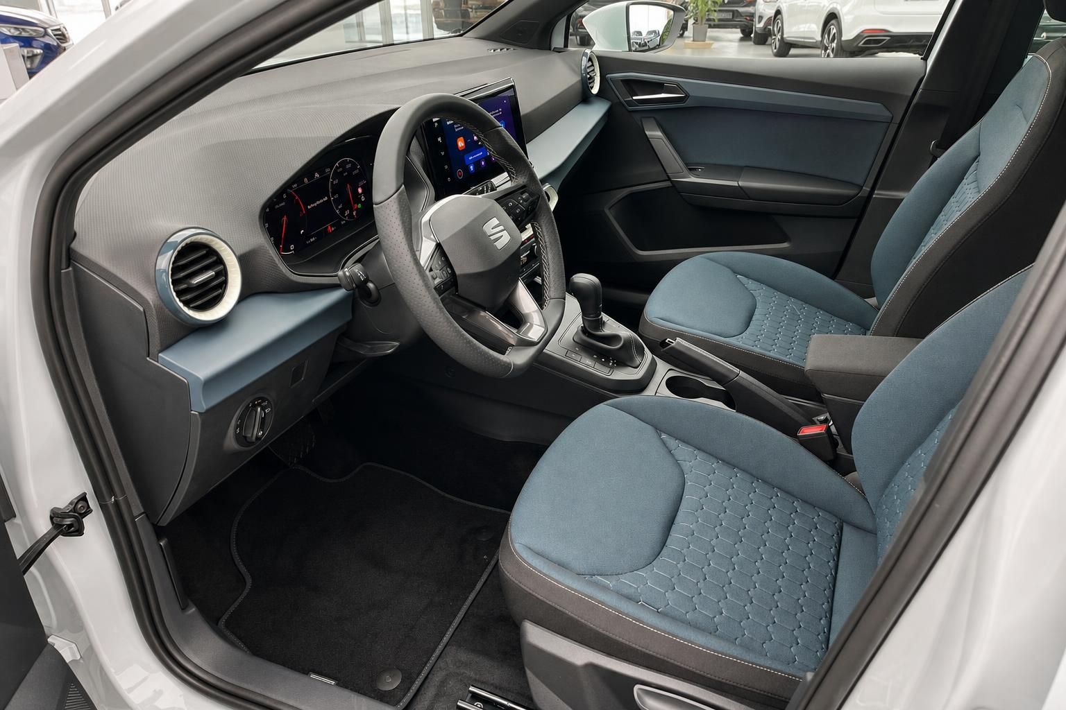 SEAT Innenraum mit blauen Sportsitzen, Lenkrad und Multimedia-Display