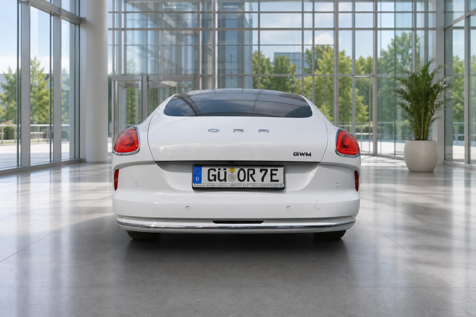 GWM ORA Elektroauto weiß Heckansicht im Autohaus mit Kennzeichen GÜ OR 7E