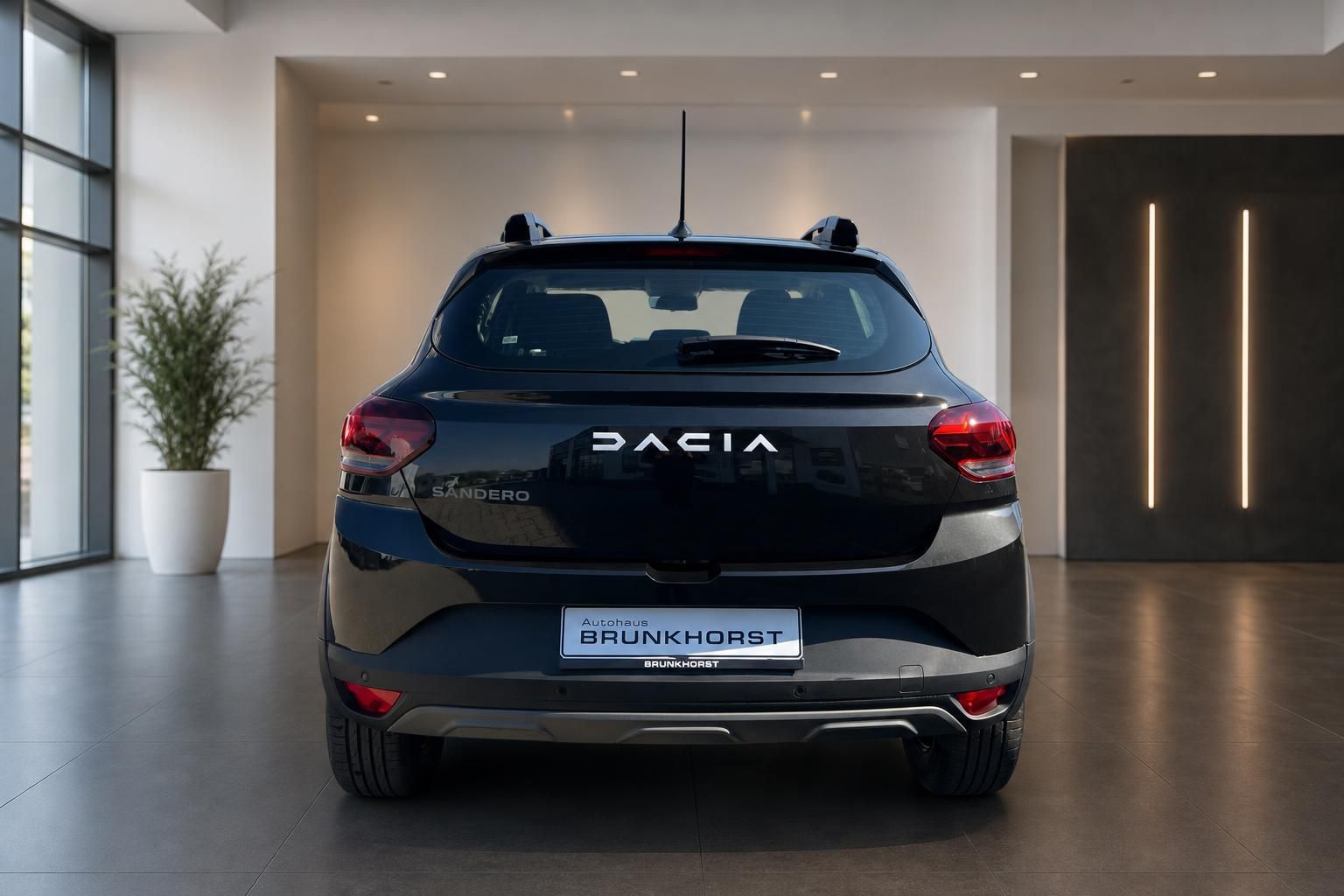 Dacia Sandero Heckansicht in grau mit DACIA Schriftzug im Autohaus Brunkhorst Showroom