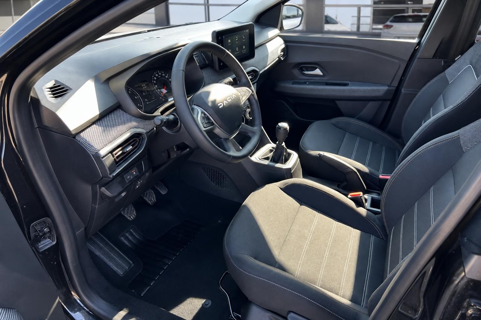 Dacia Fahrerplatz mit Lenkrad - komfortable Sitze und übersichtliches Cockpit-Design