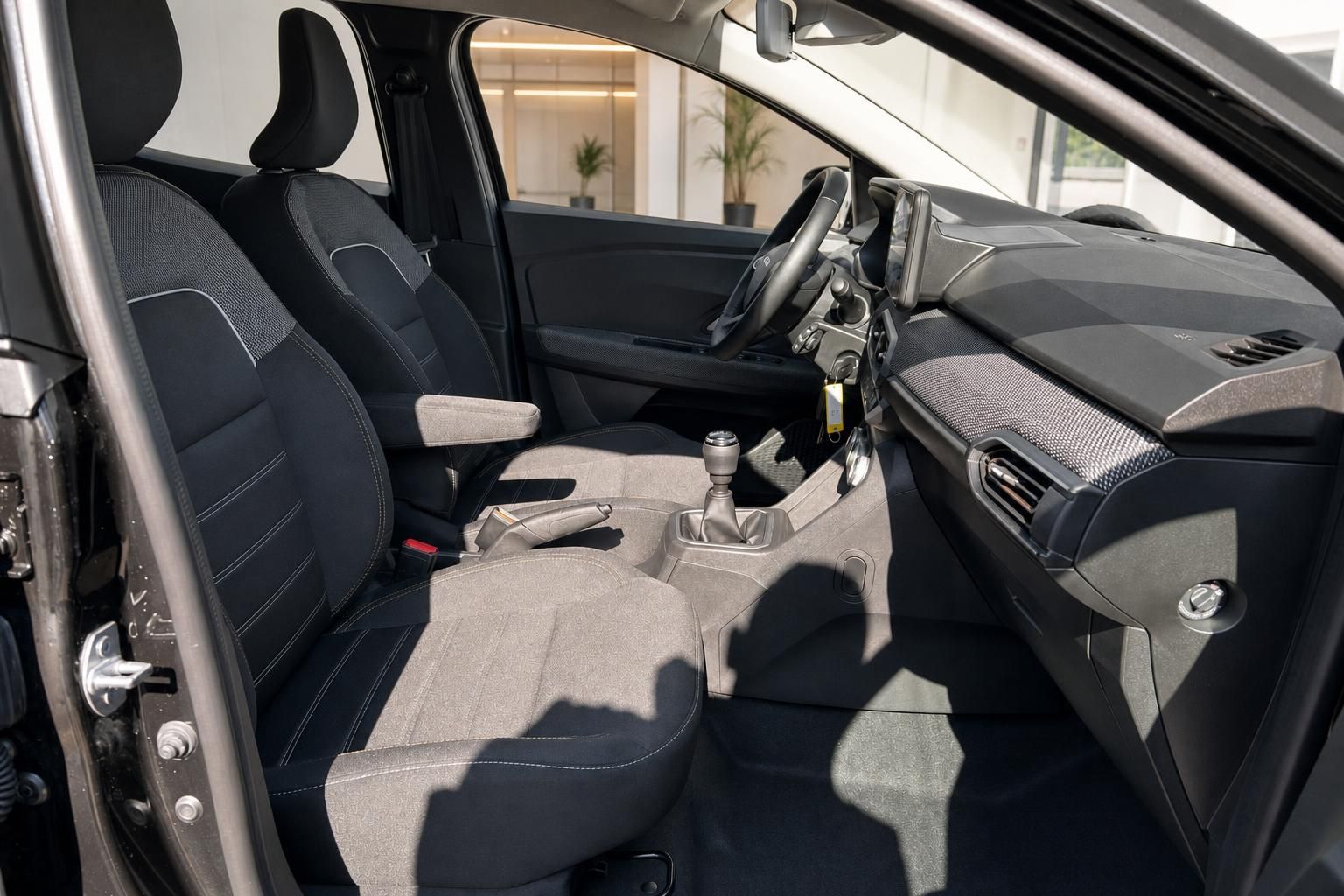 Dacia Sandero Innenraum mit grauen Sitzen, Schaltgetriebe und modernem Cockpit-Design