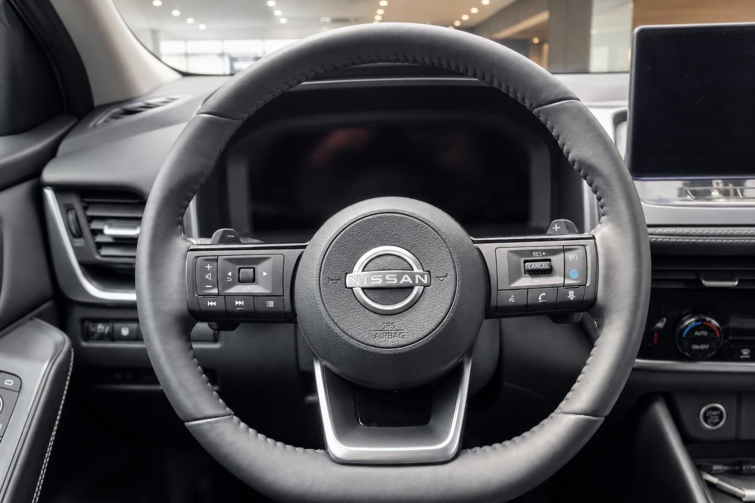 Nissan Lenkrad mit Bedienelementen und Logo im Detail