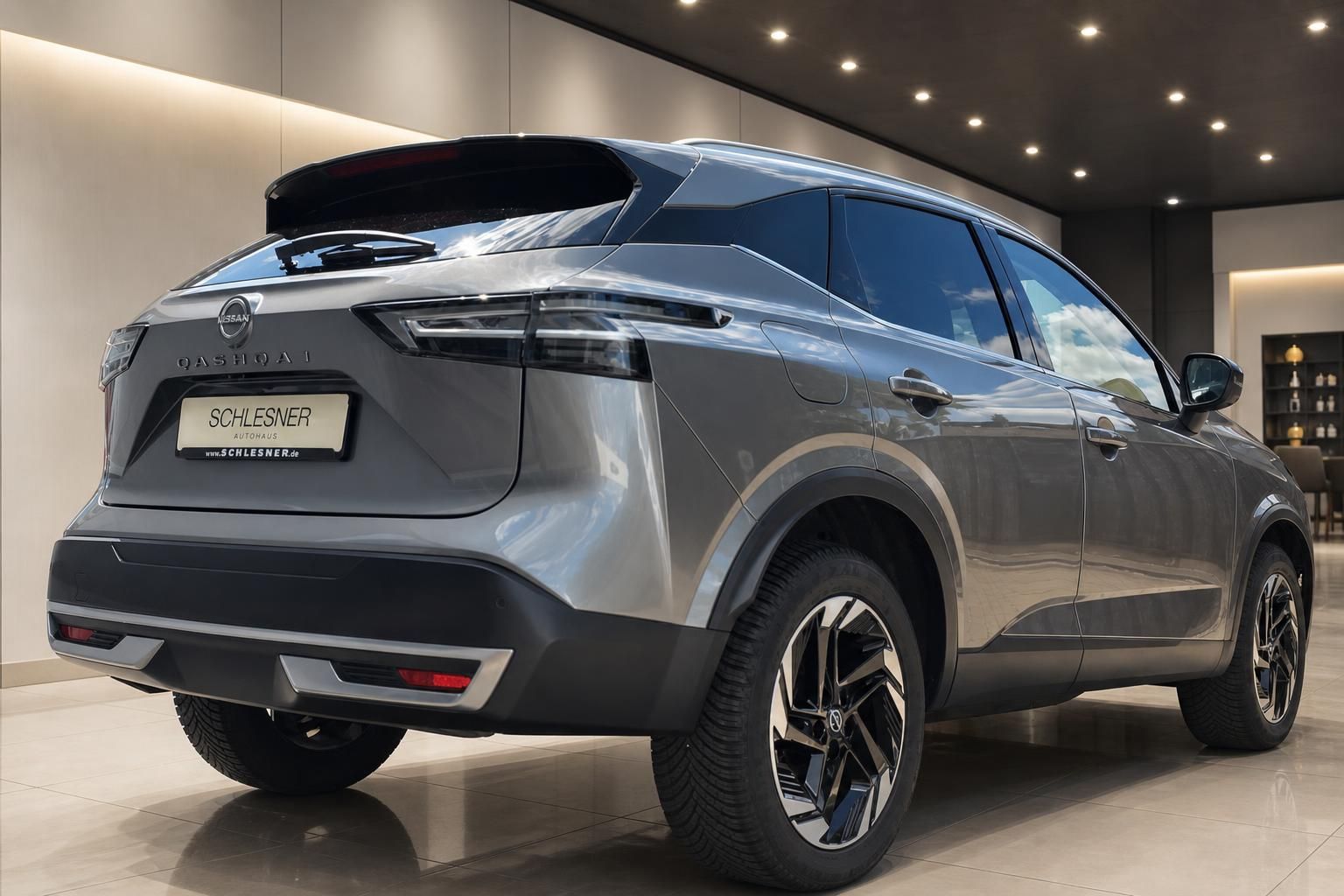 Nissan Qashqai grau, Heckansicht schraeg im modernen Showroom