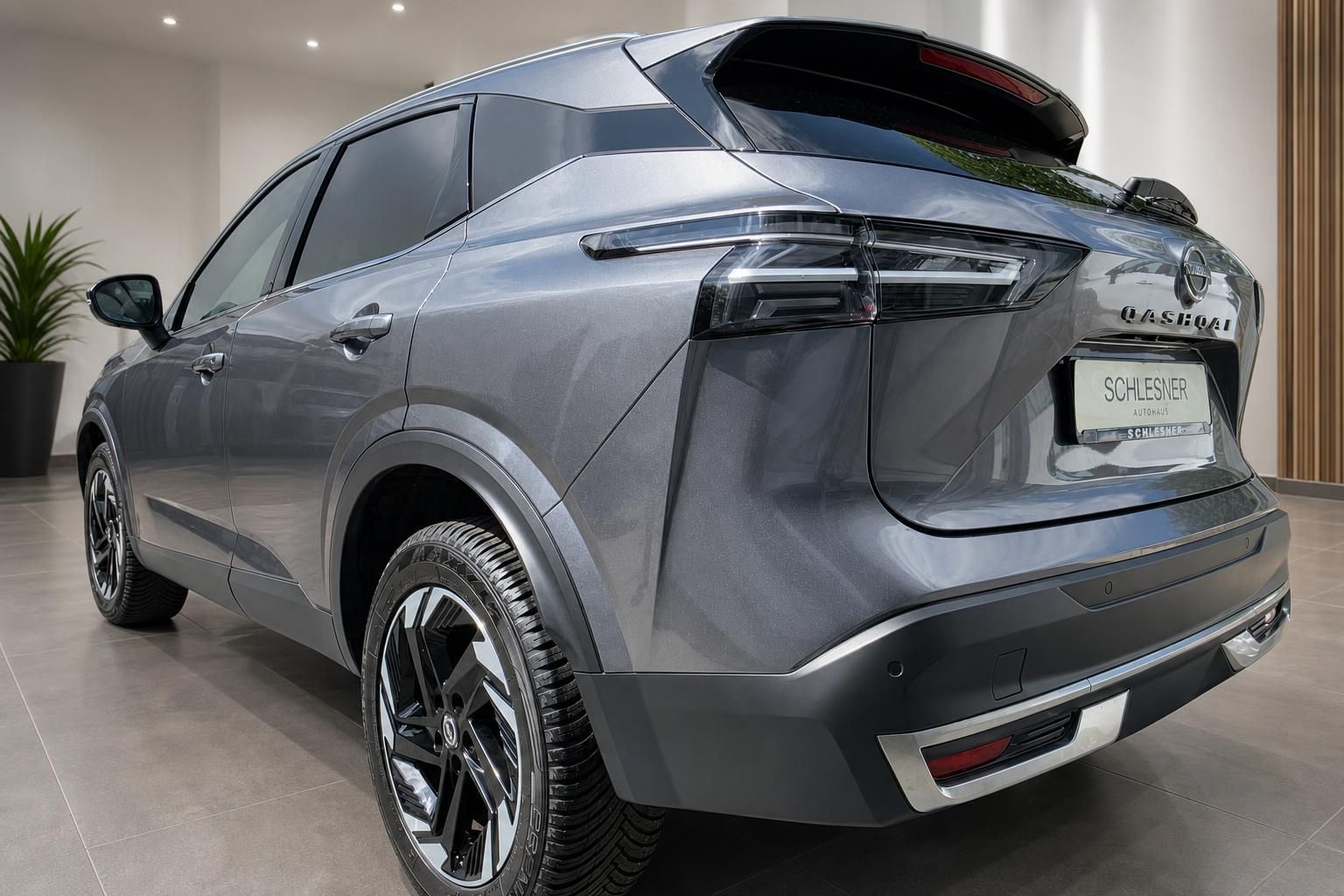 Nissan Qashqai in Grau, Heckansicht seitlich im Autohaus Schlesner