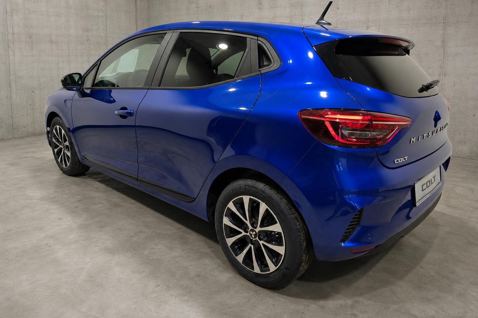 Mitsubishi Colt blau Heckansicht schraeg mit Alufelgen im Studio