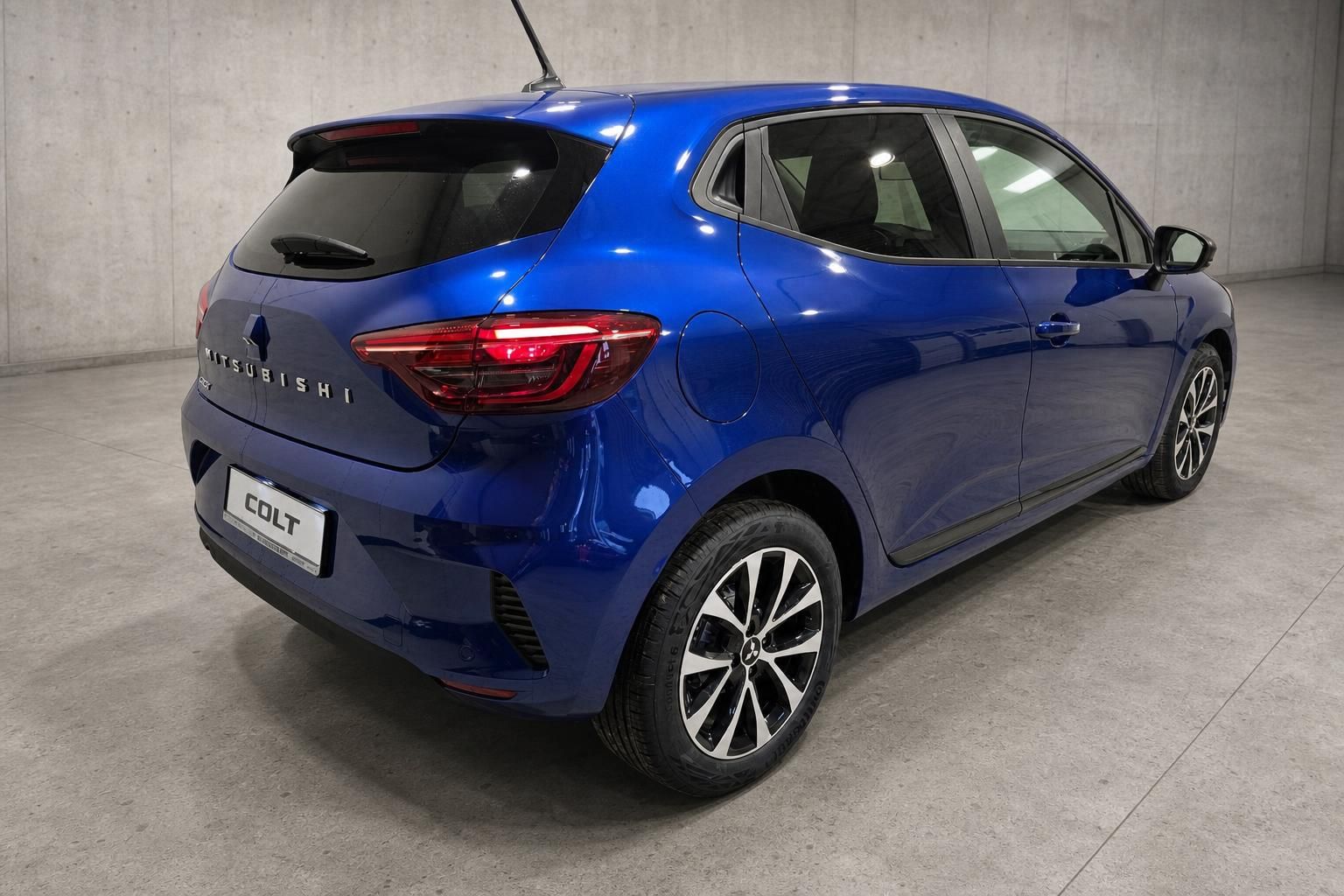 Mitsubishi Colt blau Heckansicht schraeg mit Ruecklichtern im Studio