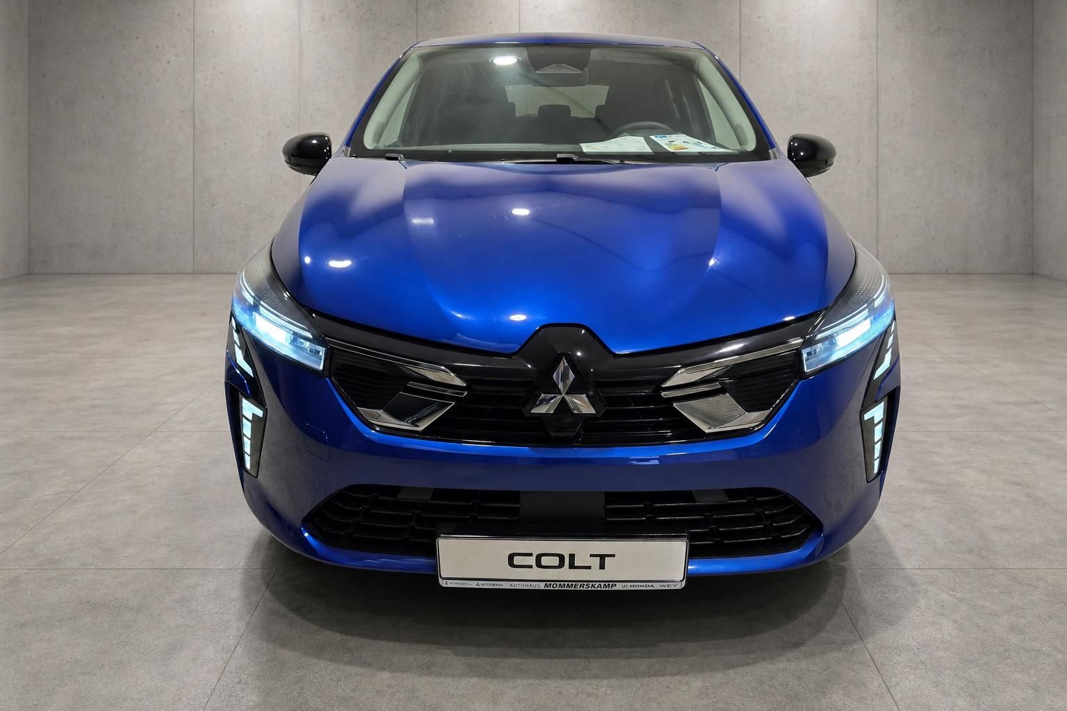 Mitsubishi Colt blau Frontansicht mit Kuehlergrill und Kennzeichen COLT