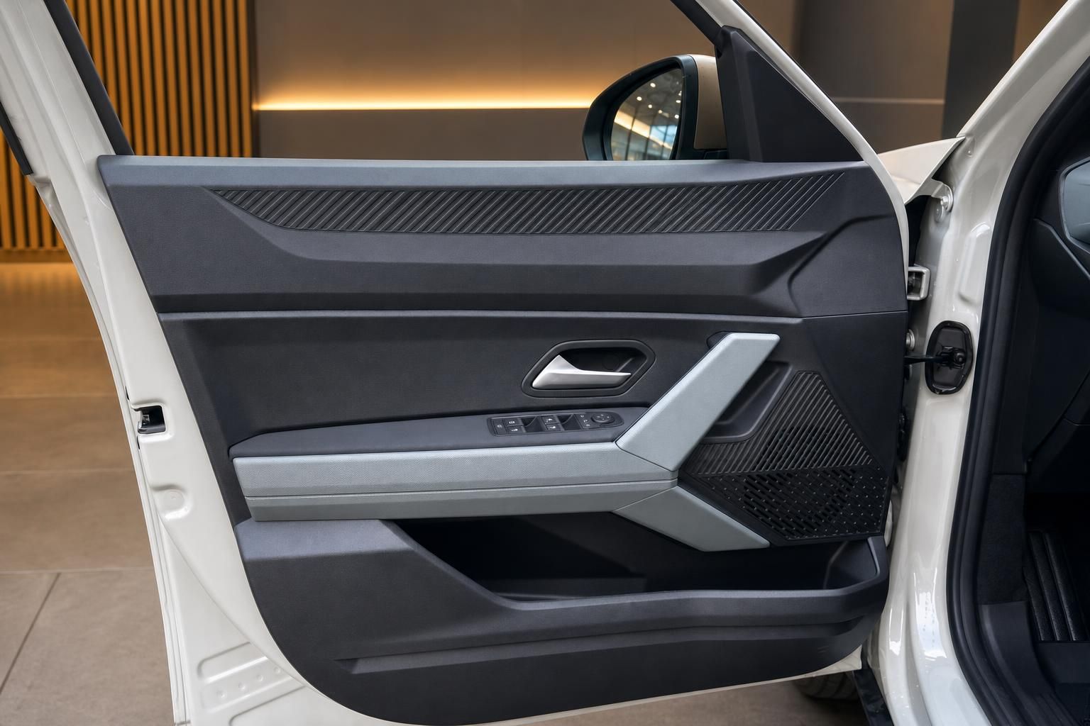 Offene Autotür mit grauer Türverkleidung und Fensterheber-Bedienung im Showroom