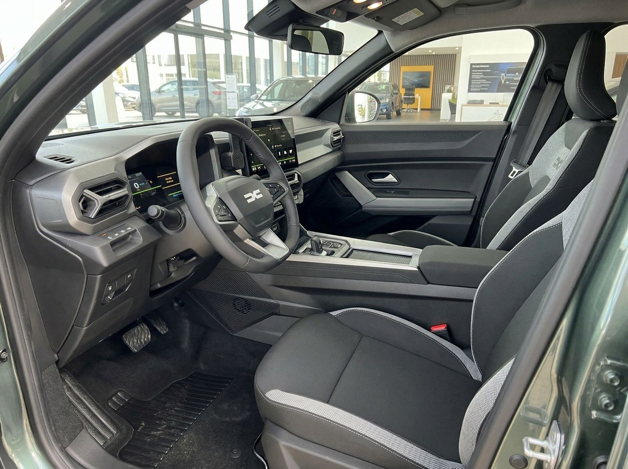 Dacia Innenraum mit modernem Cockpit - Lenkrad, Digitalanzeigen und graue Sportsitze