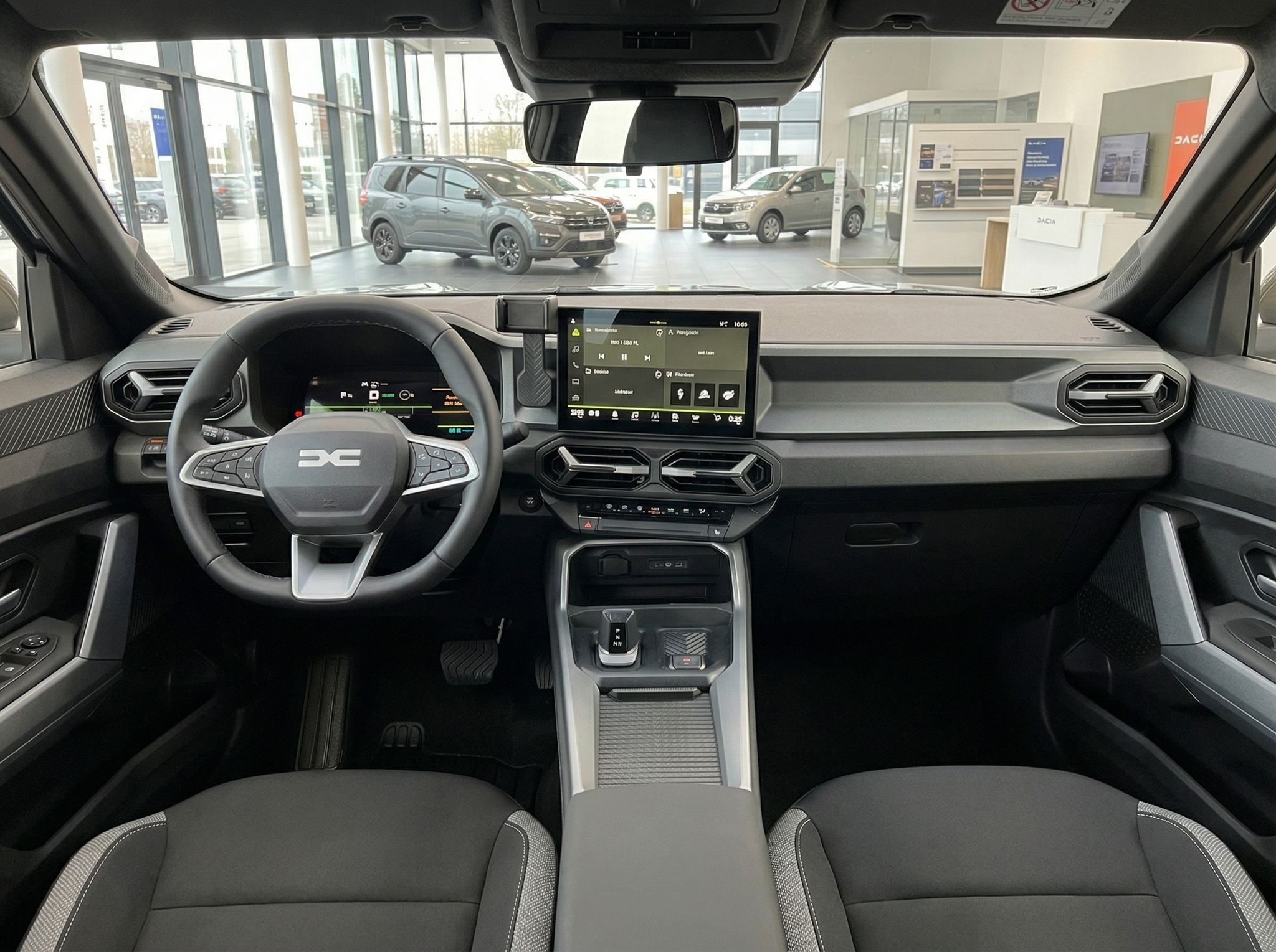 Innenraum eines Fahrzeugs mit modernem Cockpit, Touchscreen und Blick auf Autohaus-Showroom