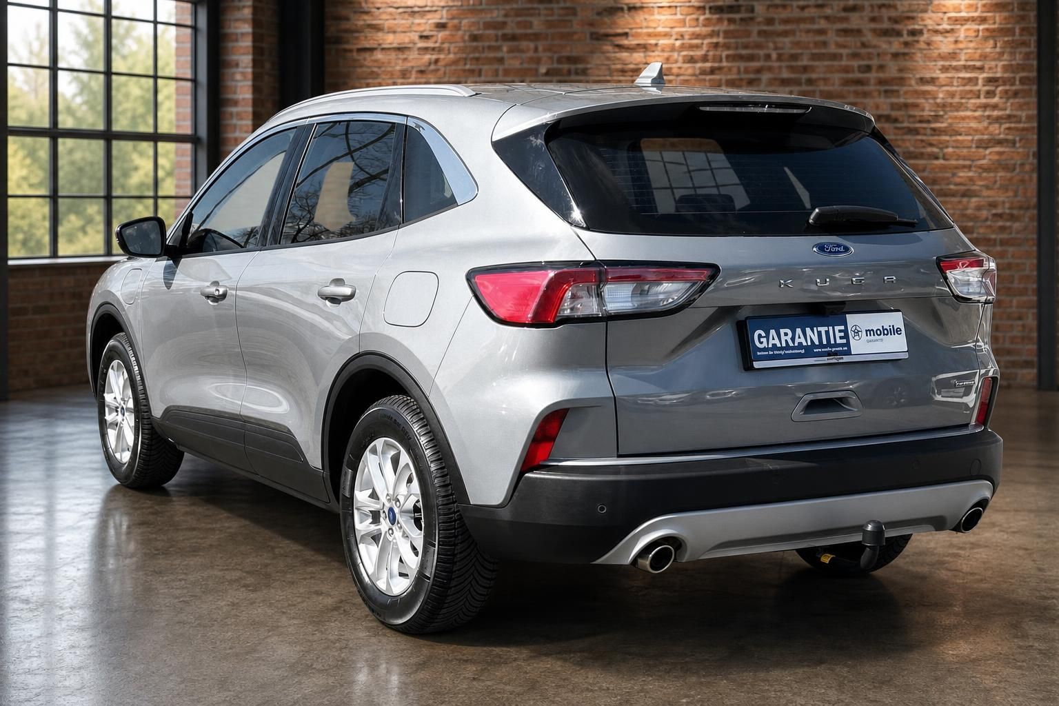 Ford Kuga silber, Heckansicht schraeg mit Anhaengerkupplung
