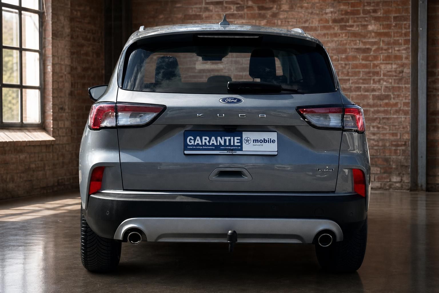 Ford Kuga Hybrid grau, direkte Heckansicht mit Anhaengerkupplung