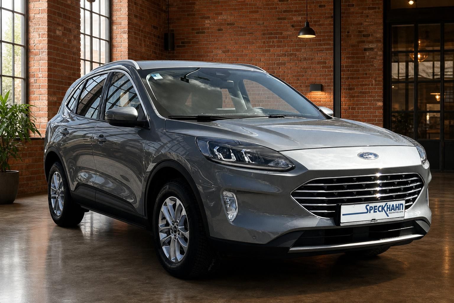 Ford Kuga grau, Frontansicht schraeg im Showroom mit Backsteinwand