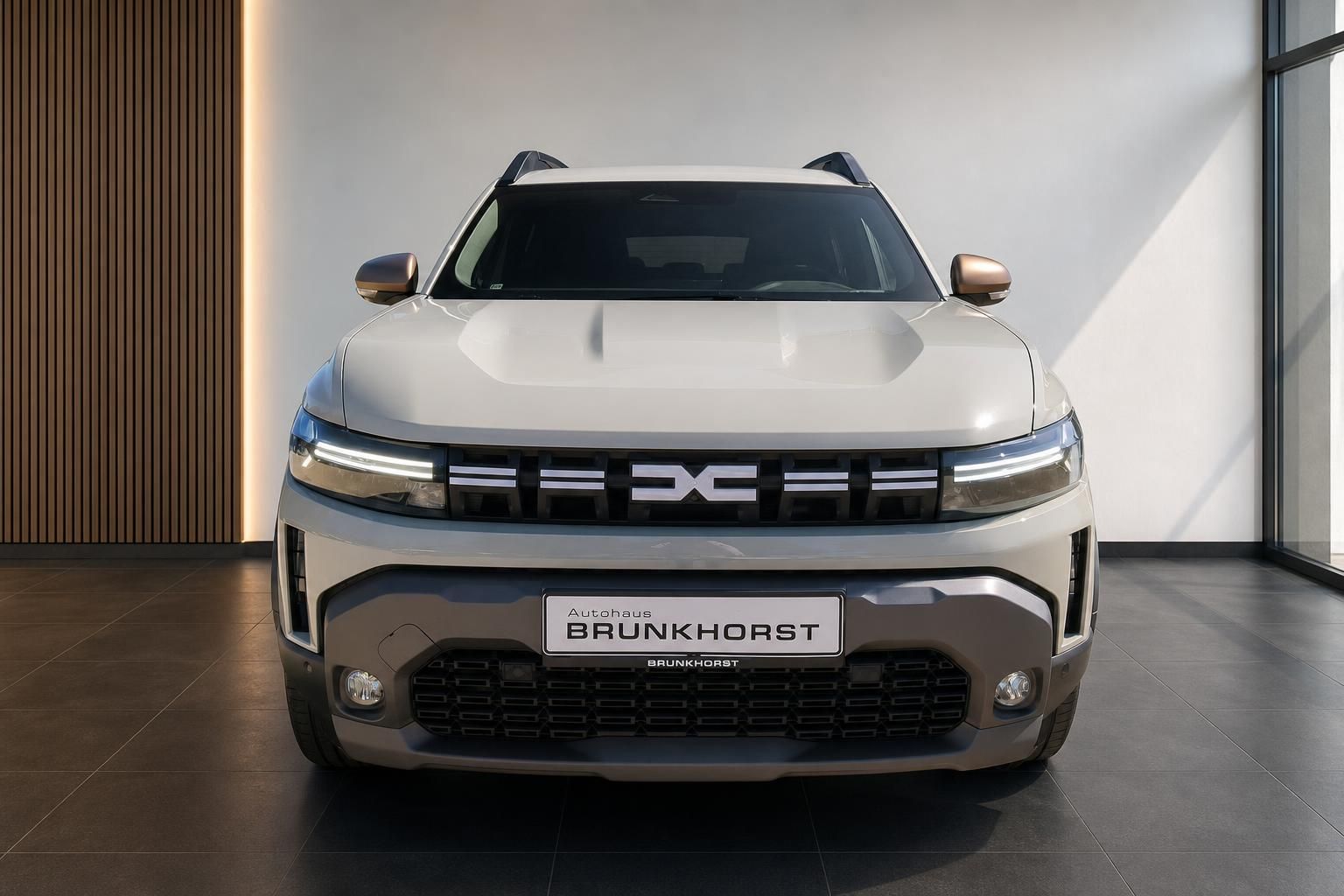 Dacia Duster SUV Frontansicht in Beige mit markanter Frontpartie im Autohaus