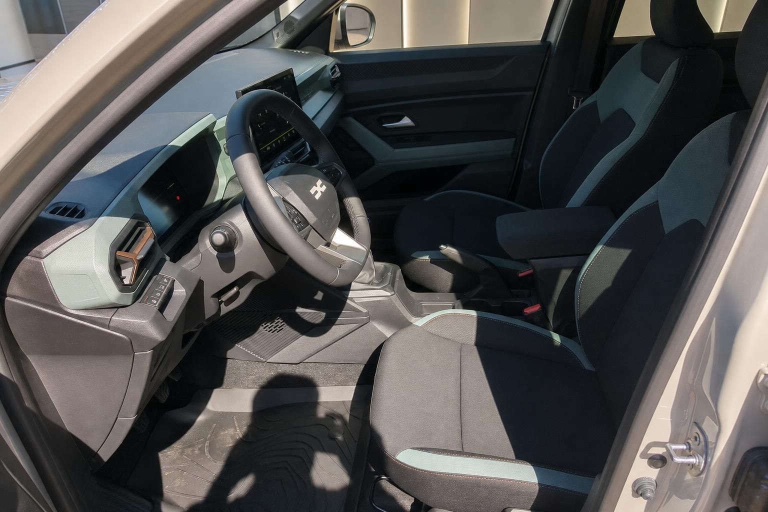 Dacia Duster Innenraum mit Lenkrad, Cockpit und Vordersitzen in Schwarz-Grün