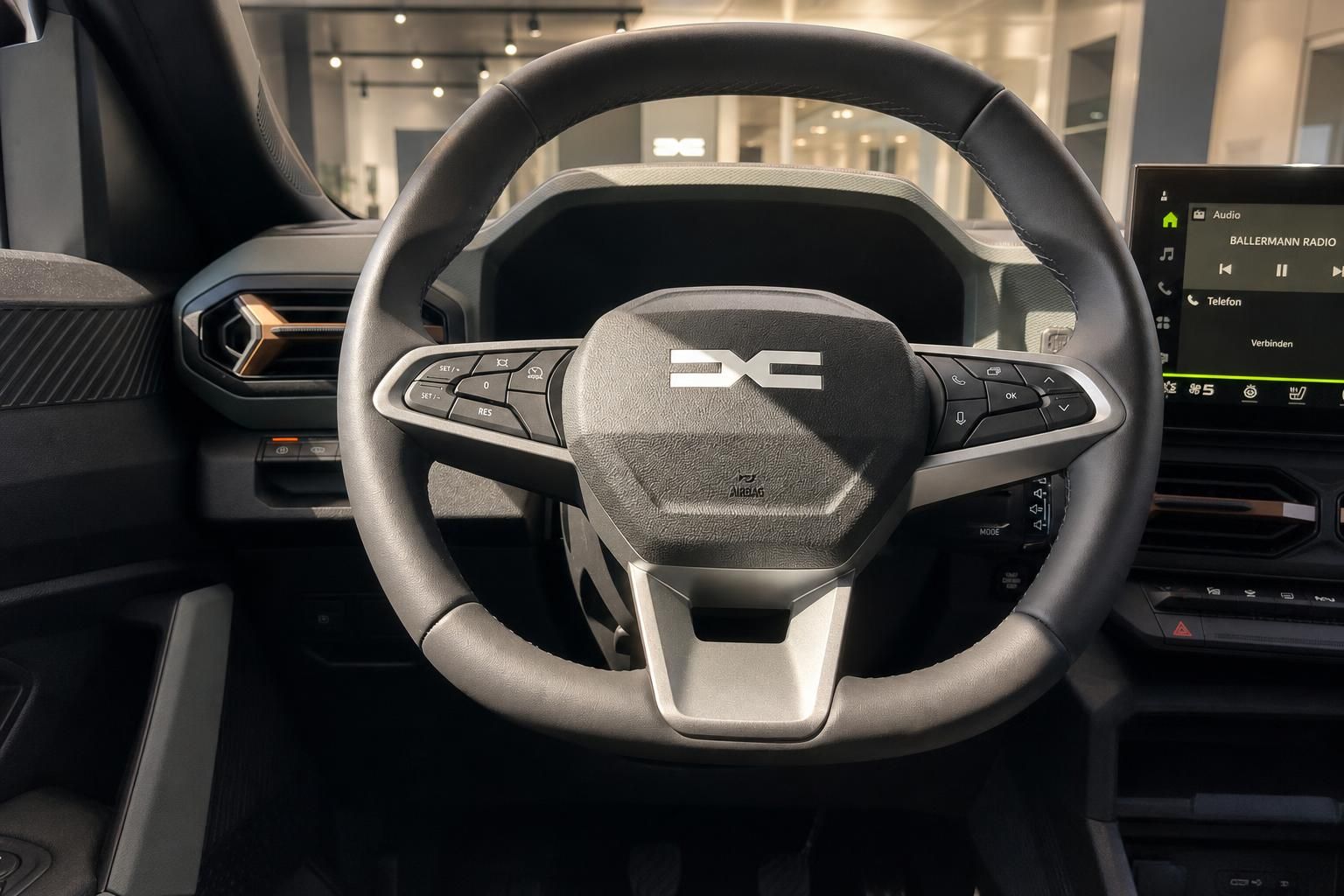 Dacia Duster Lenkrad mit Dacia-Logo und Infotainment-Display im Innenraum