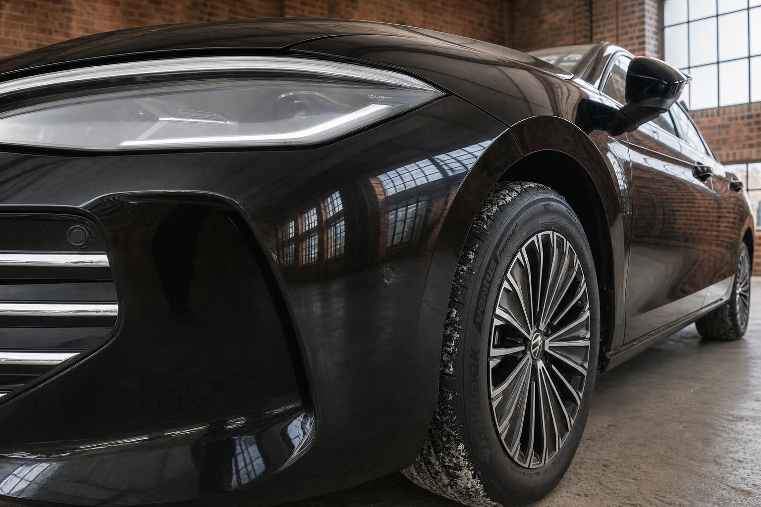 Detailaufnahme Frontscheinwerfer und Felge des schwarzen VW Limousine