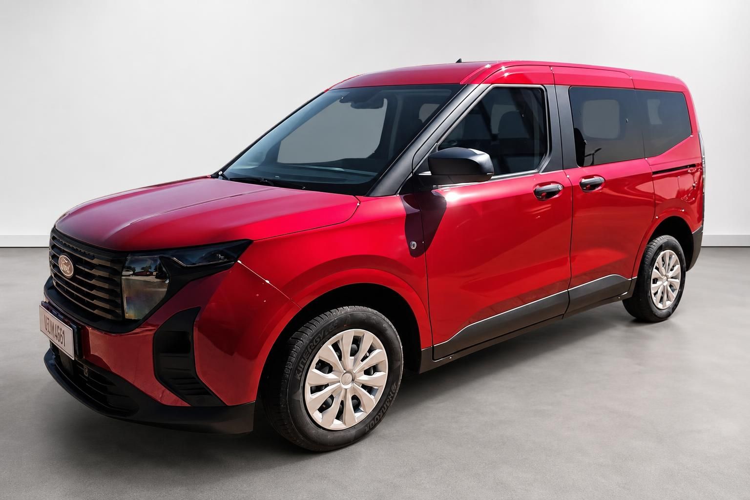Roter Ford Tourneo Courier von vorne schräg, Kompaktvan im Showroom