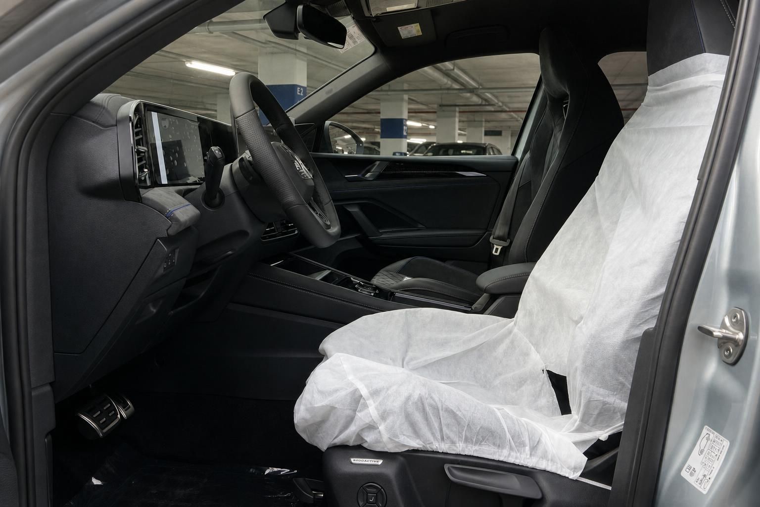VW Tiguan Innenraum mit Sportsitzen und Schutzbezug im Autohaus