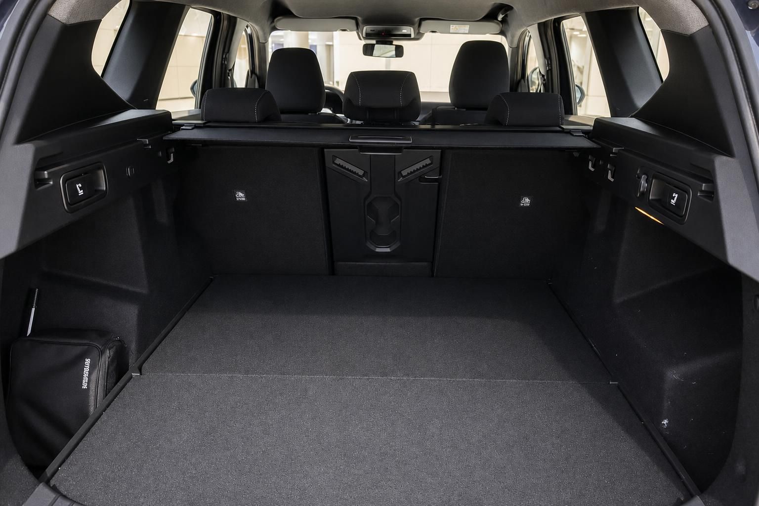 Geräumiger Kofferraum eines SUV mit ausgeklappten Rücksitzen und schwarzem Teppichboden