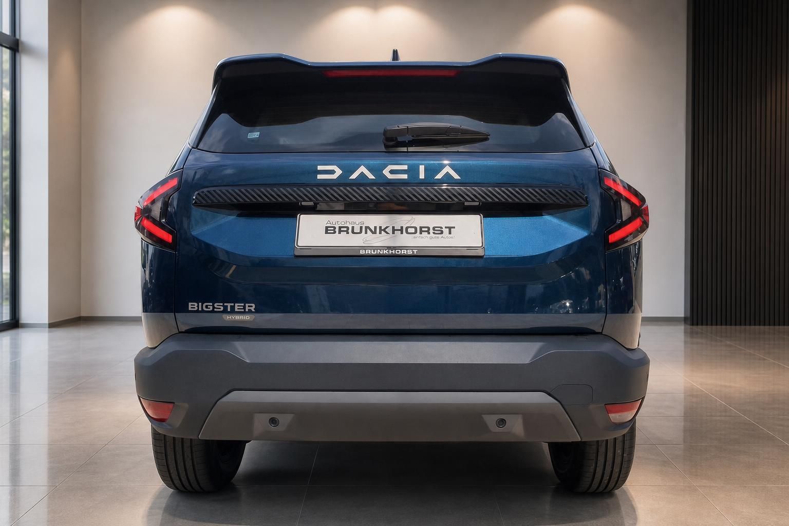 Dacia Bigster Hybrid blau Heckansicht mit DACIA Schriftzug im Autohaus Showroom