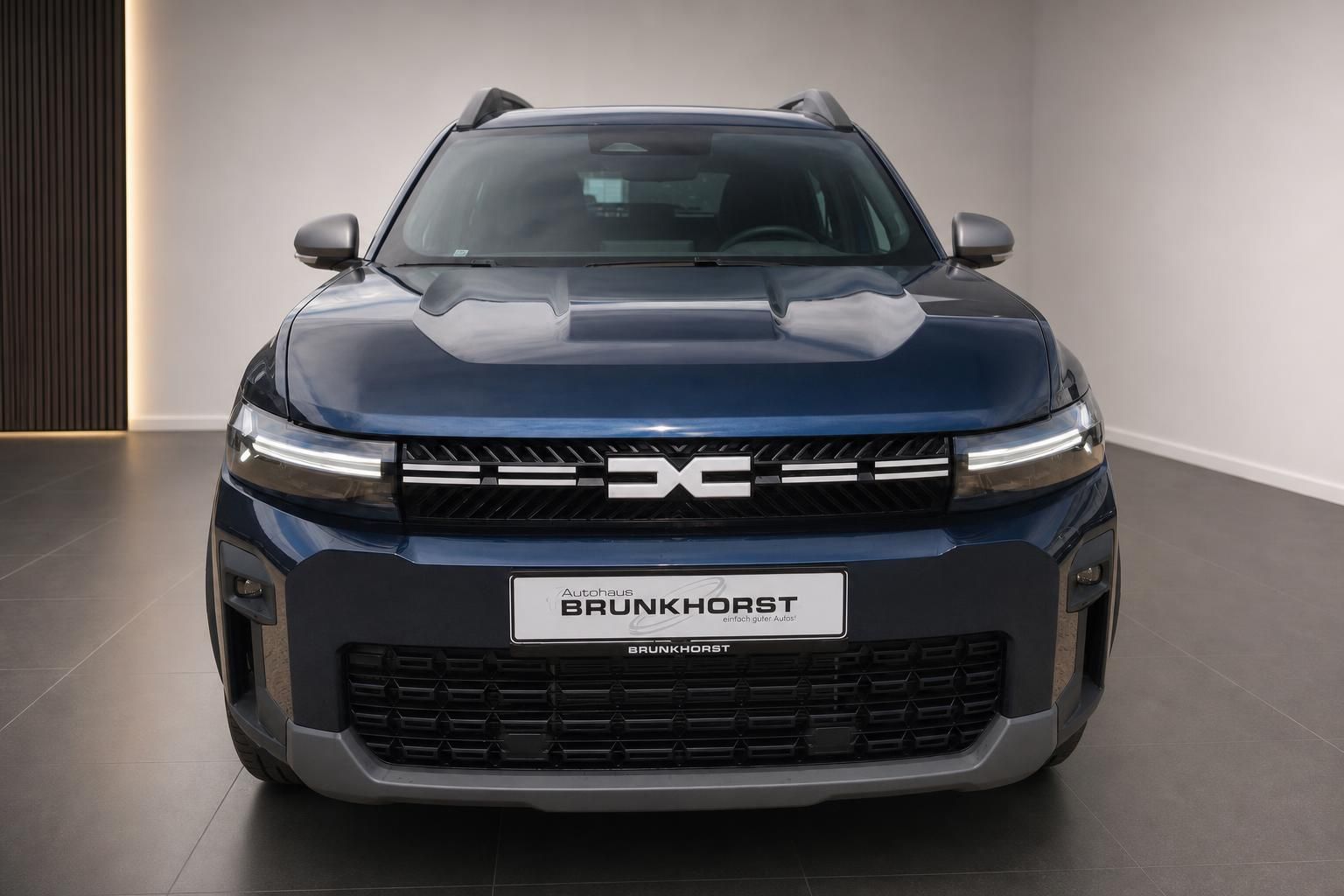 Dacia Bigster Hybrid blau Frontansicht gerade im Autohaus Brunkhorst Showroom