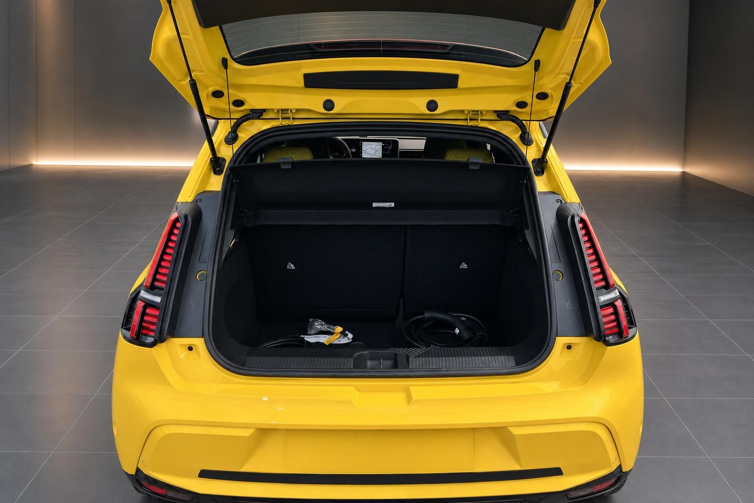 Renault 5 E-Tech Elektro gelb – geöffneter Kofferraum mit Ladekabel von hinten