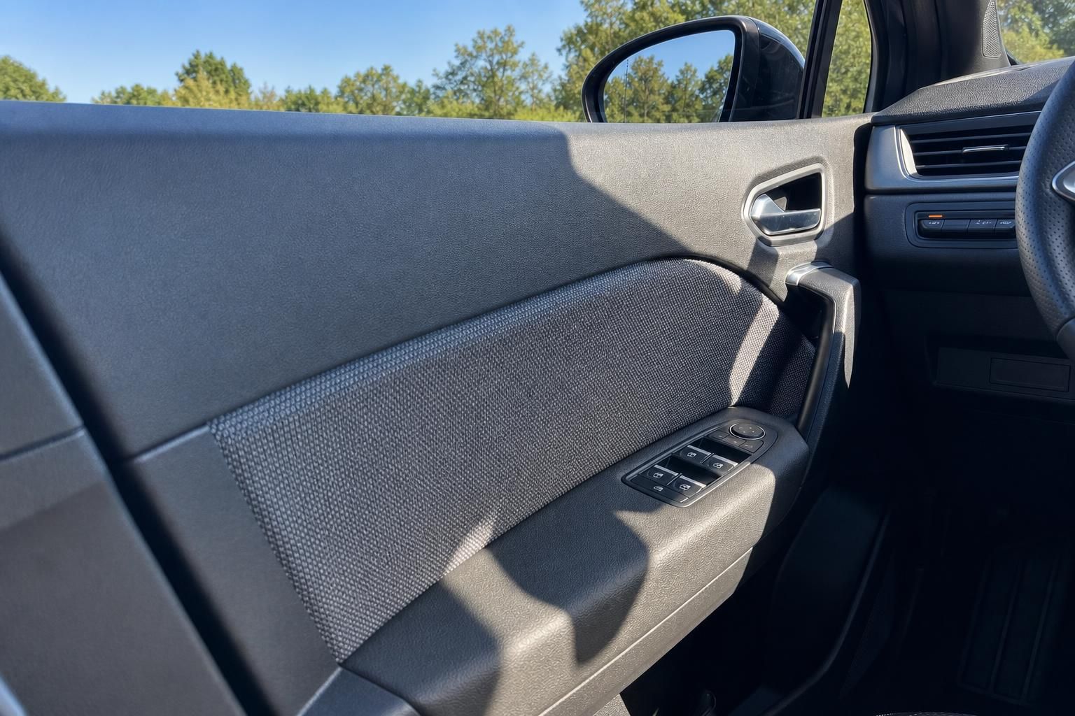 Fahrzeug Türverkleidung mit Fensterheber-Bedienung und grauem Textil